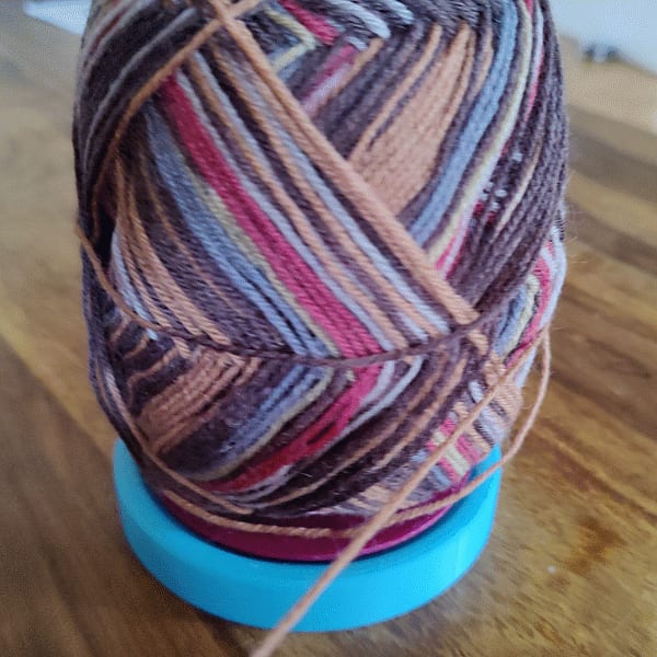 Yarn ball holder with ball bearing knitting gadget