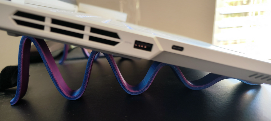 Sinusoidal laptop stand with attenuation