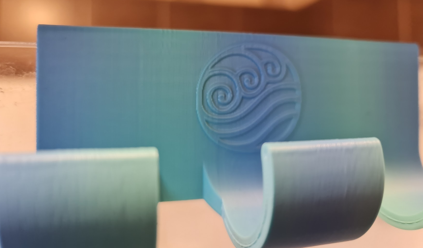 Shower hook with water tribe logo