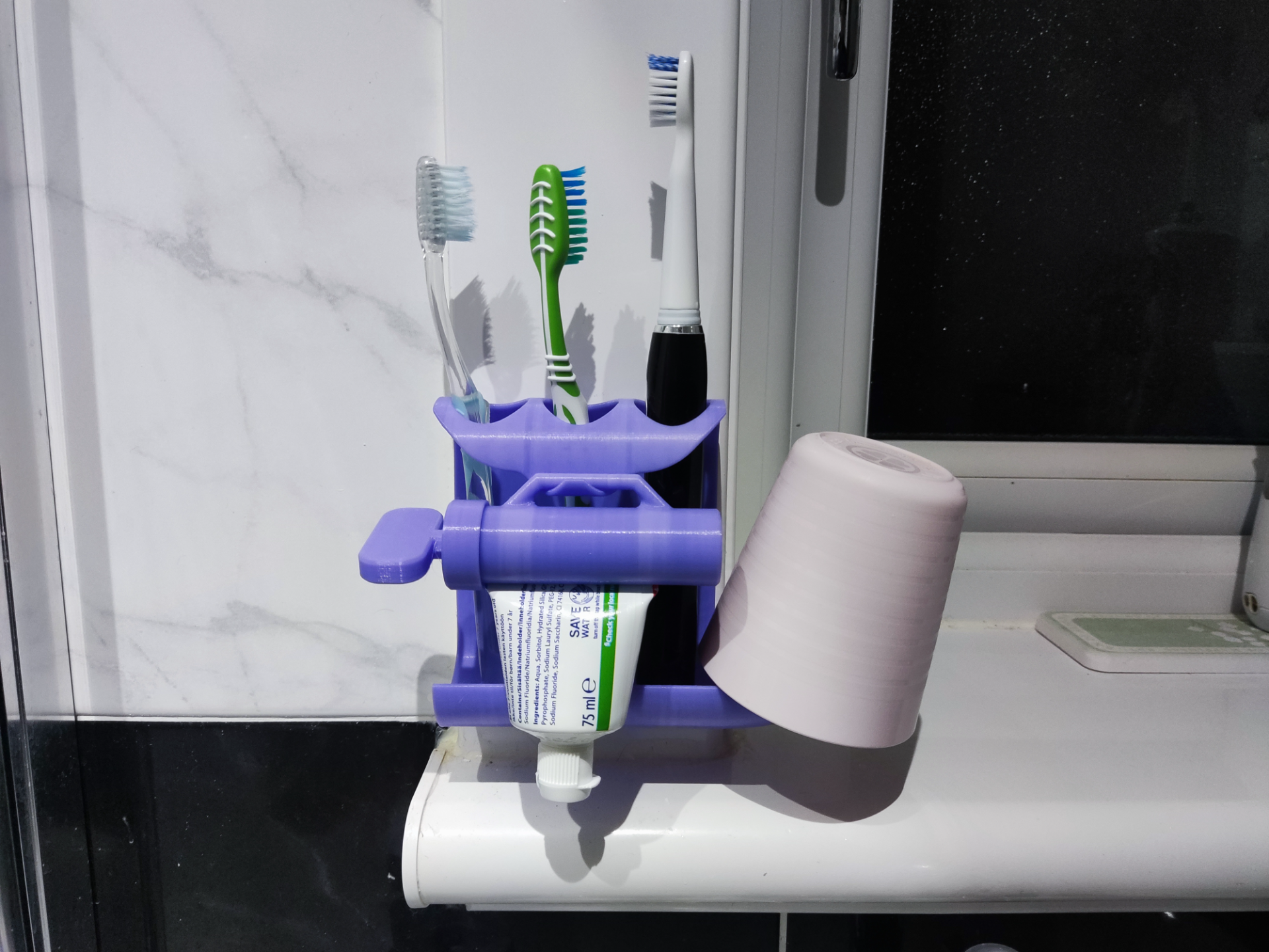 Toothpaste squeezer and toothbrush holder